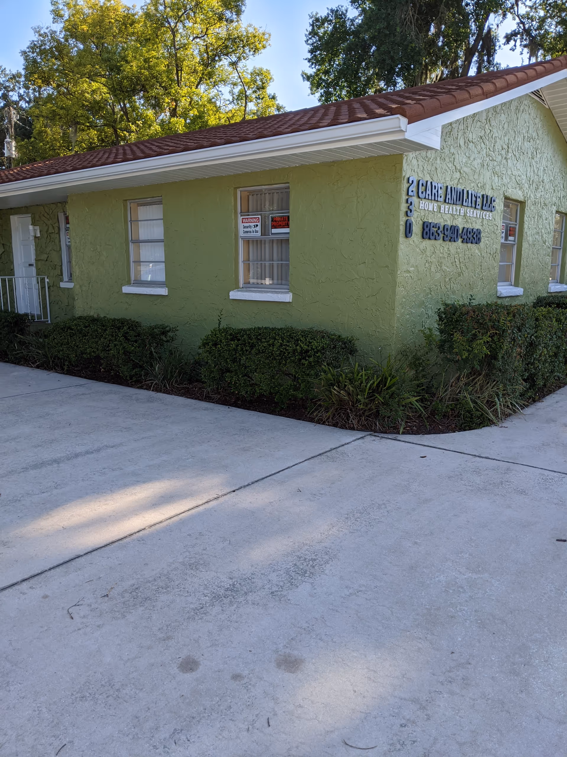 Green single-story care facility labeled Care and Life LLC with windows.