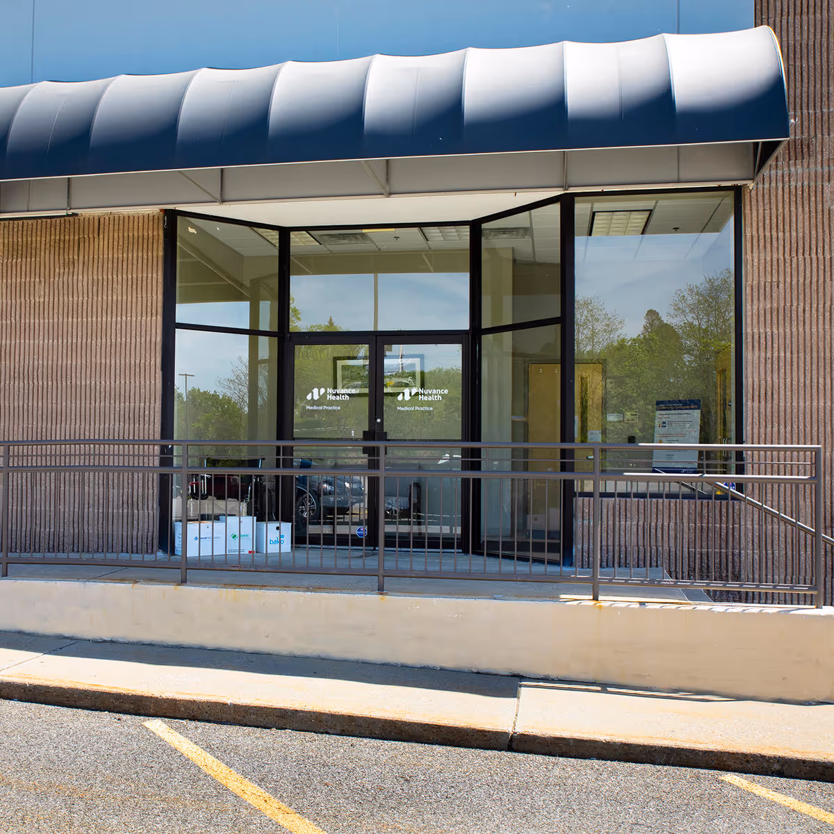 Front entrance to Nuvance Health Medical Practice with glass doors and a blue awning.