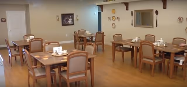 Dining room at Maple Ridge Manor of Manistee with multiple tables and place settings.