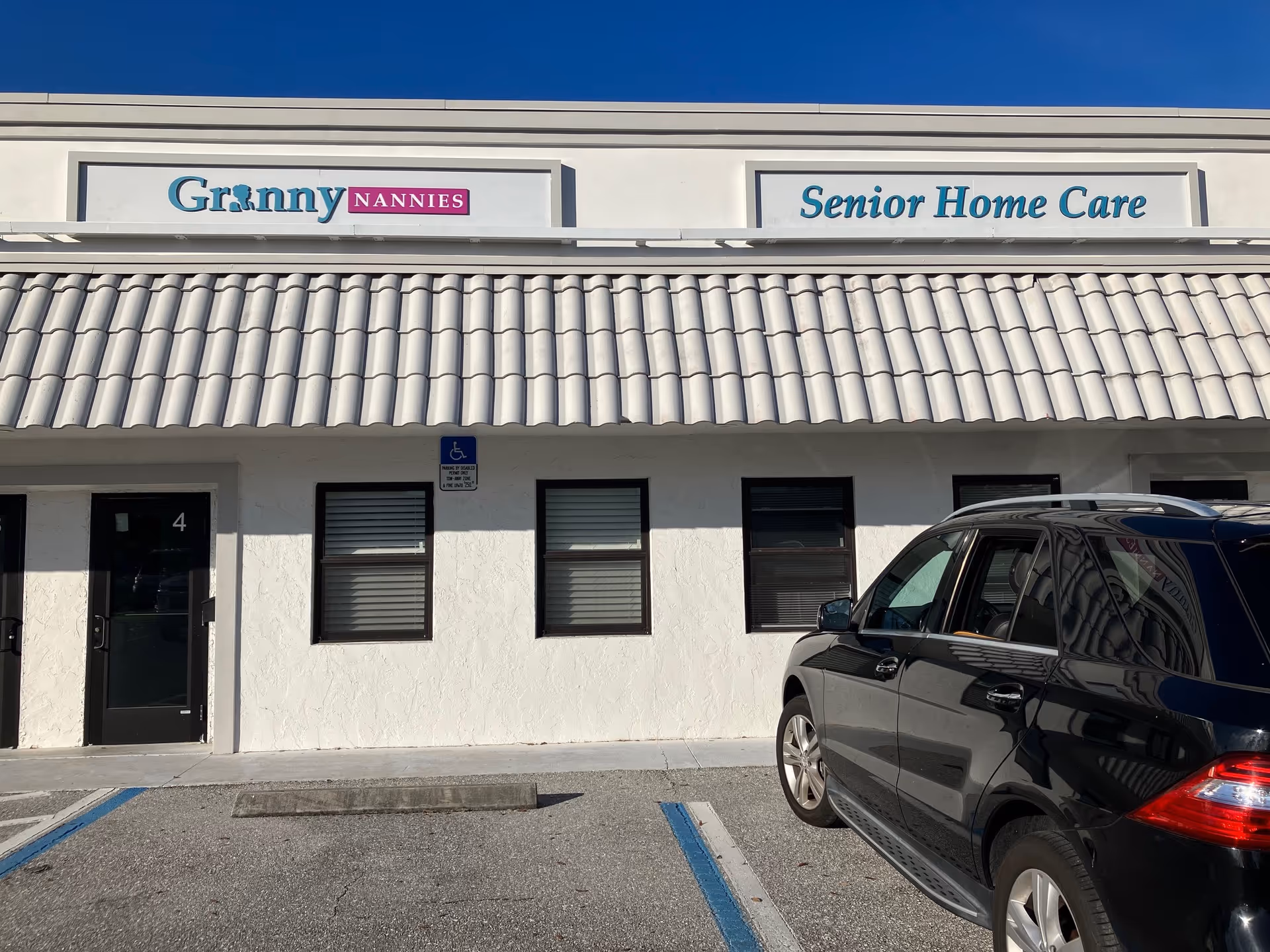 Front of Granny Nannies Senior Home Care facility with parked car in lot.