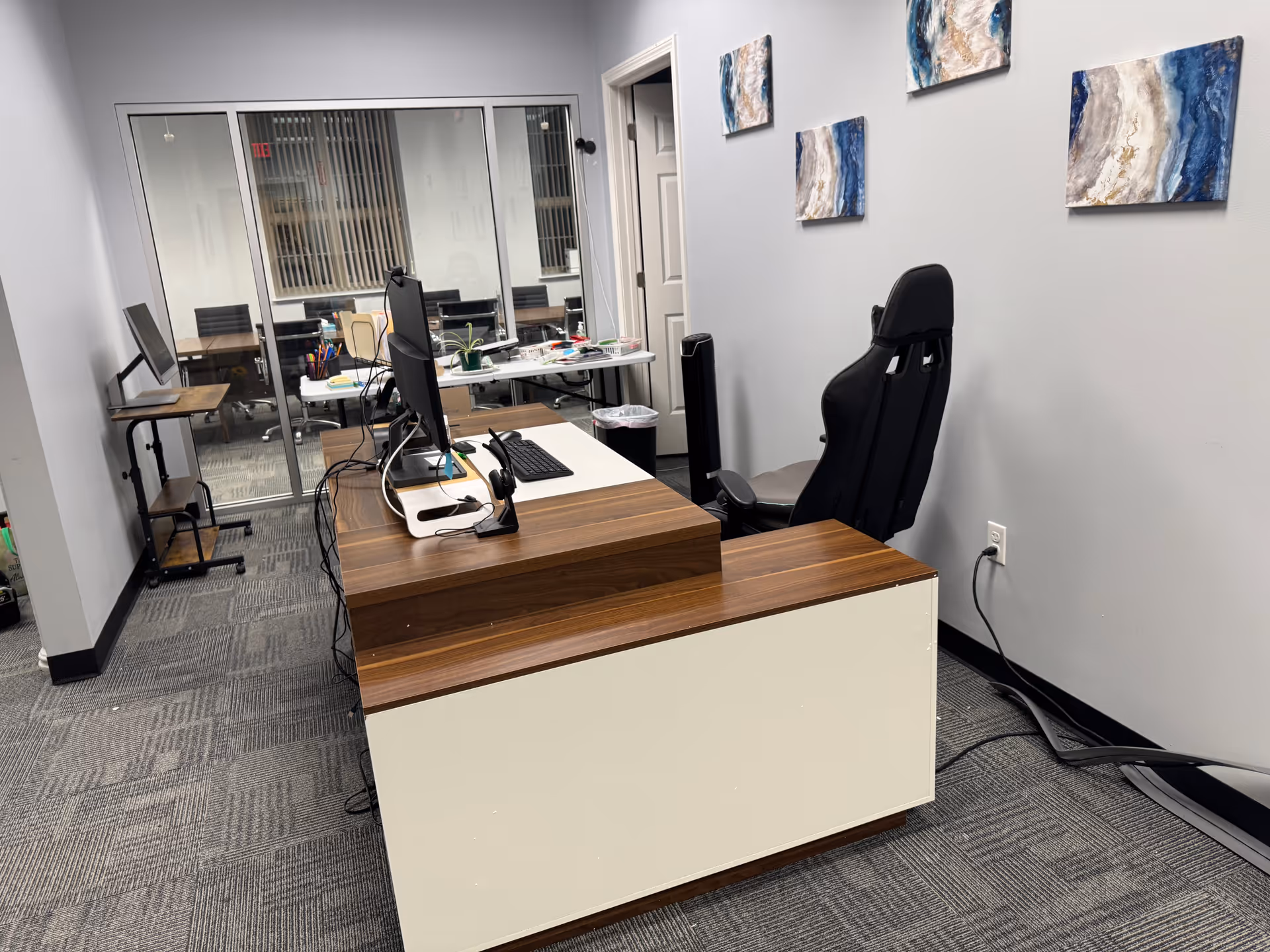 A modern reception desk with computer, headset, and chairs inside a facility