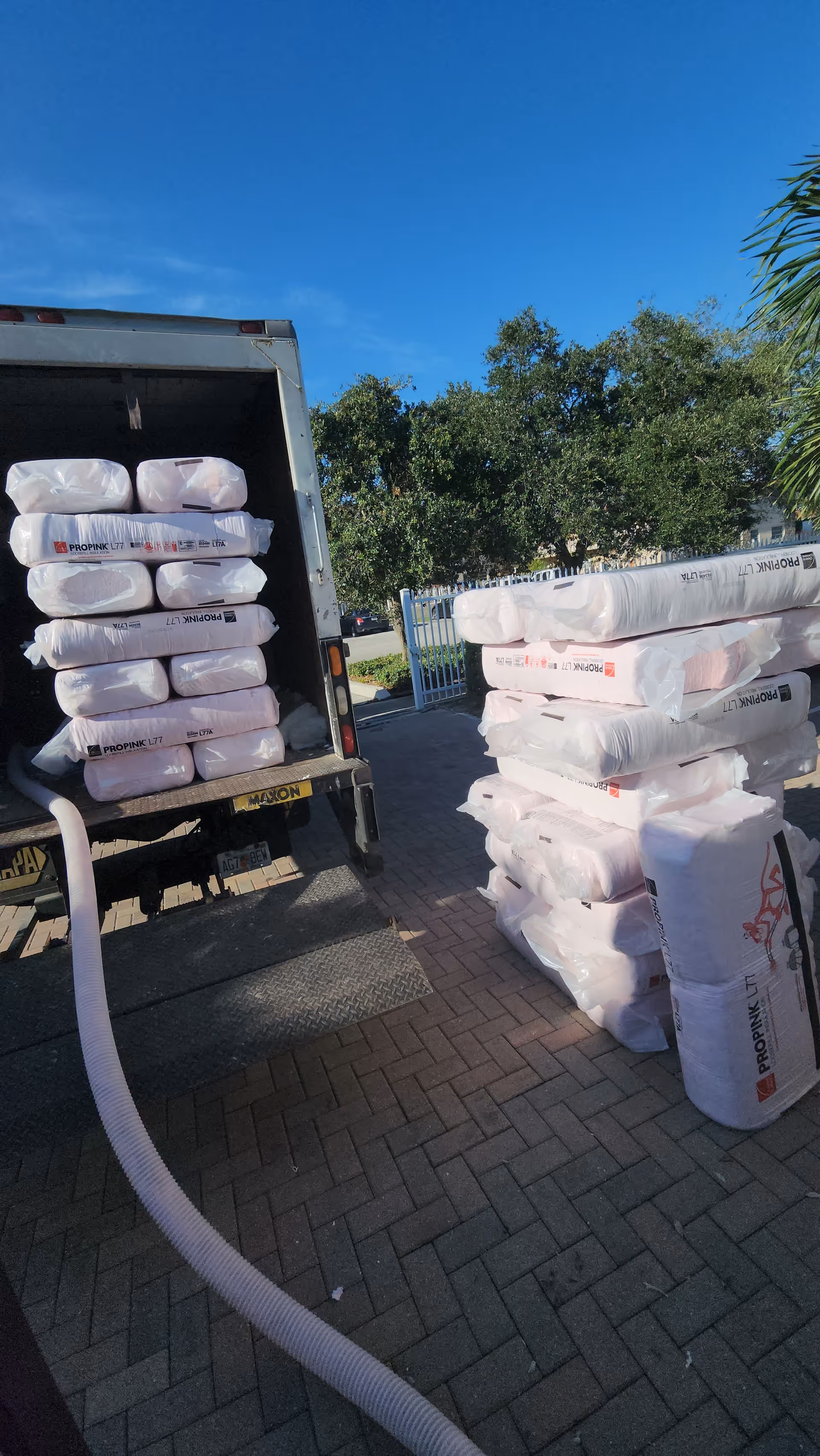 Back of a truck unloading large white bags outside a senior living facility.