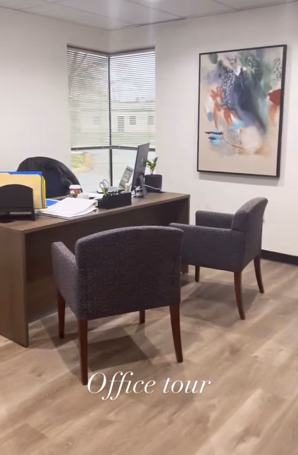 Office desk with two upholstered chairs, windows, abstract painting, and Office tour overlay.