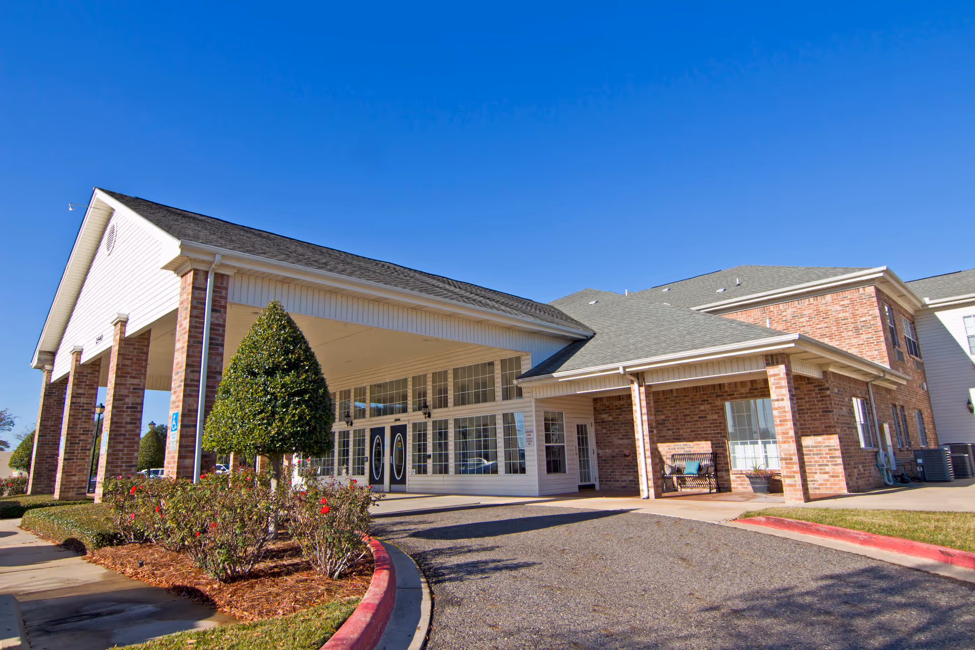 Front exterior of Brookdale Bossier City senior living facility with brick columns and a glass entrance.
