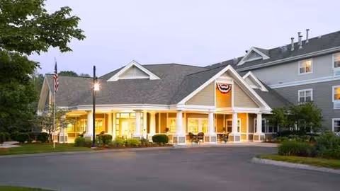 Atria Kennebunk exterior with a lit entrance and bunting.