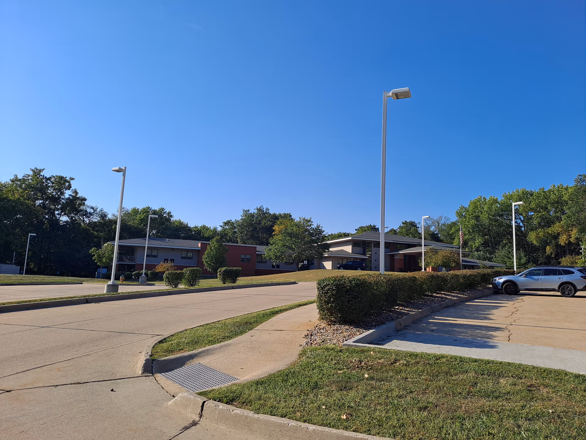 Exterior view of EveryStep senior living facility with parking, driveway, and blue sky.