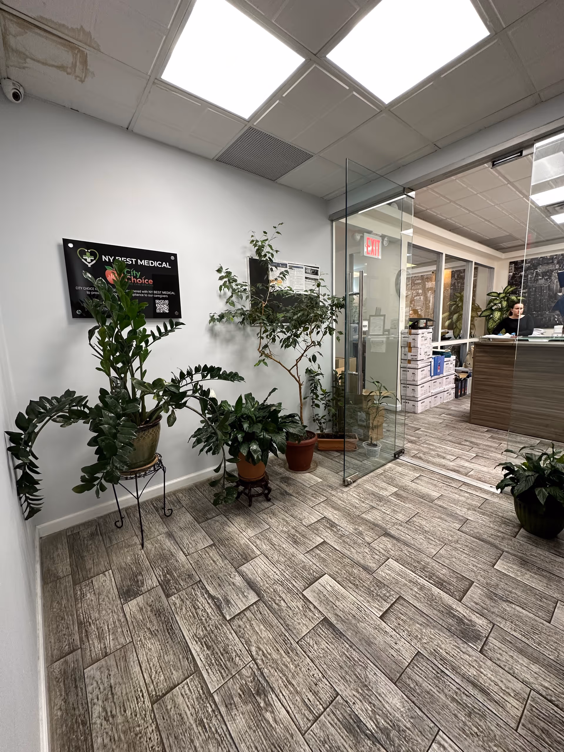 Indoor lobby of City Choice Home Care Services, with potted plants, glass door, and reception desk.