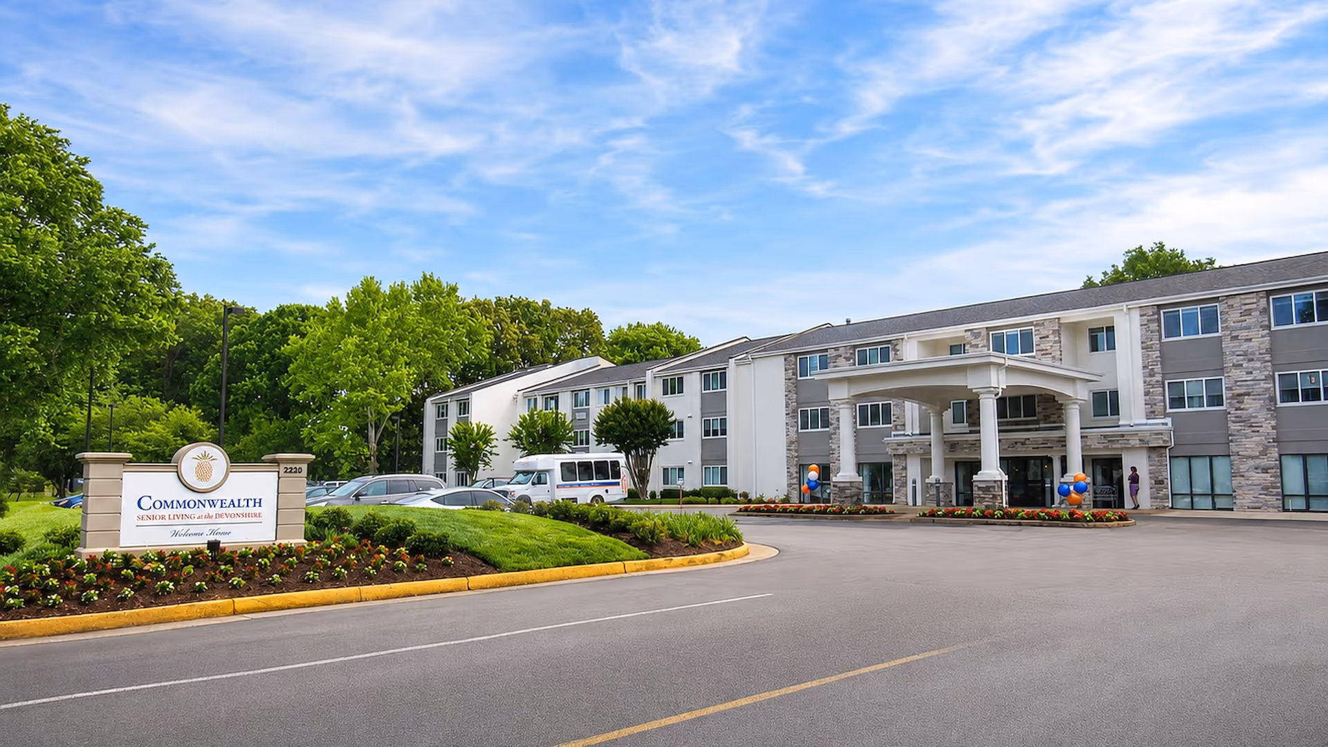 Exterior view of Commonwealth Senior Living at the Devonshire with entrance canopy and landscaped grounds.