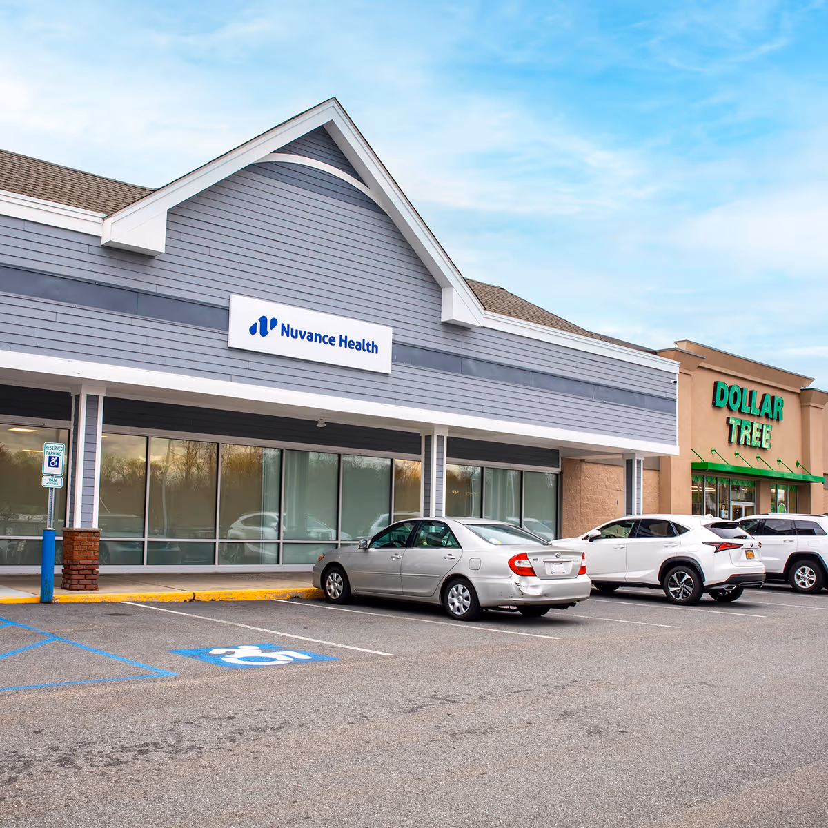 Front exterior of a strip mall with Nuvance Health signage and a nearby Dollar Tree