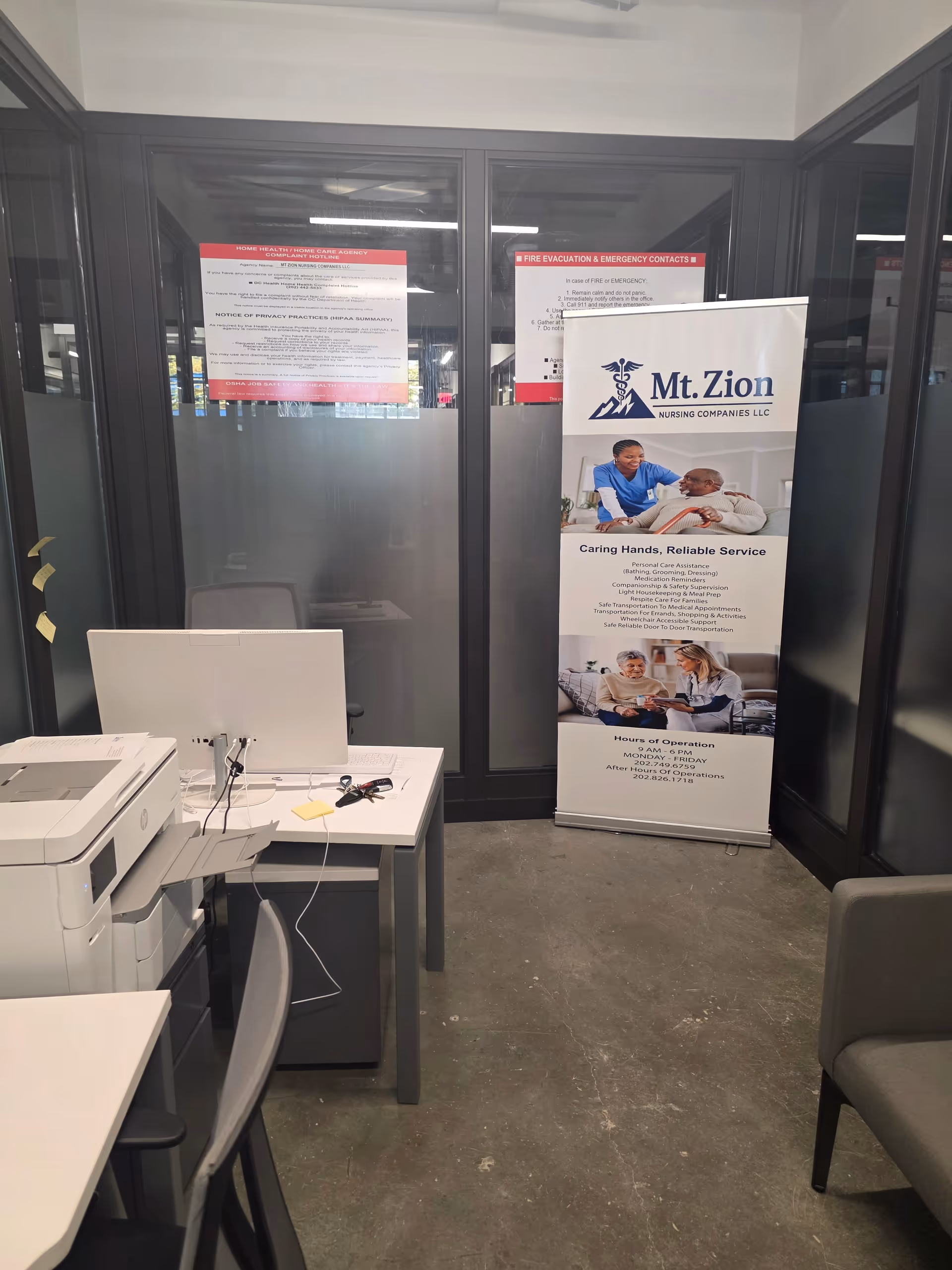 Office reception area with printer, computer, and Mt. Zion Nursing banner.
