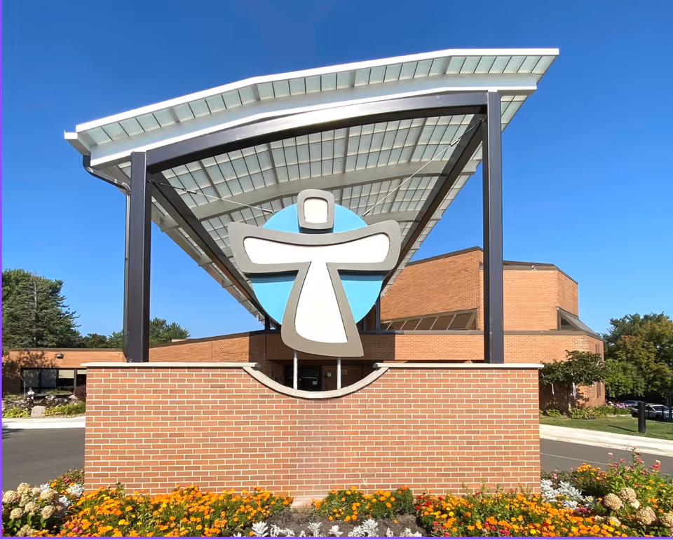 Exterior view of Our Lady of Peace Hospice entrance with brick façade and large sign.