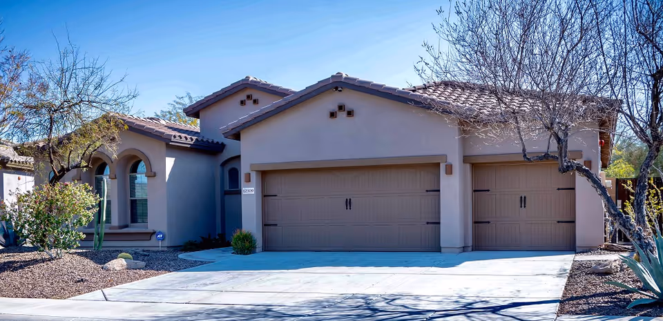 Front exterior of a single-story assisted living facility with a three-car garage and desert landscaping.