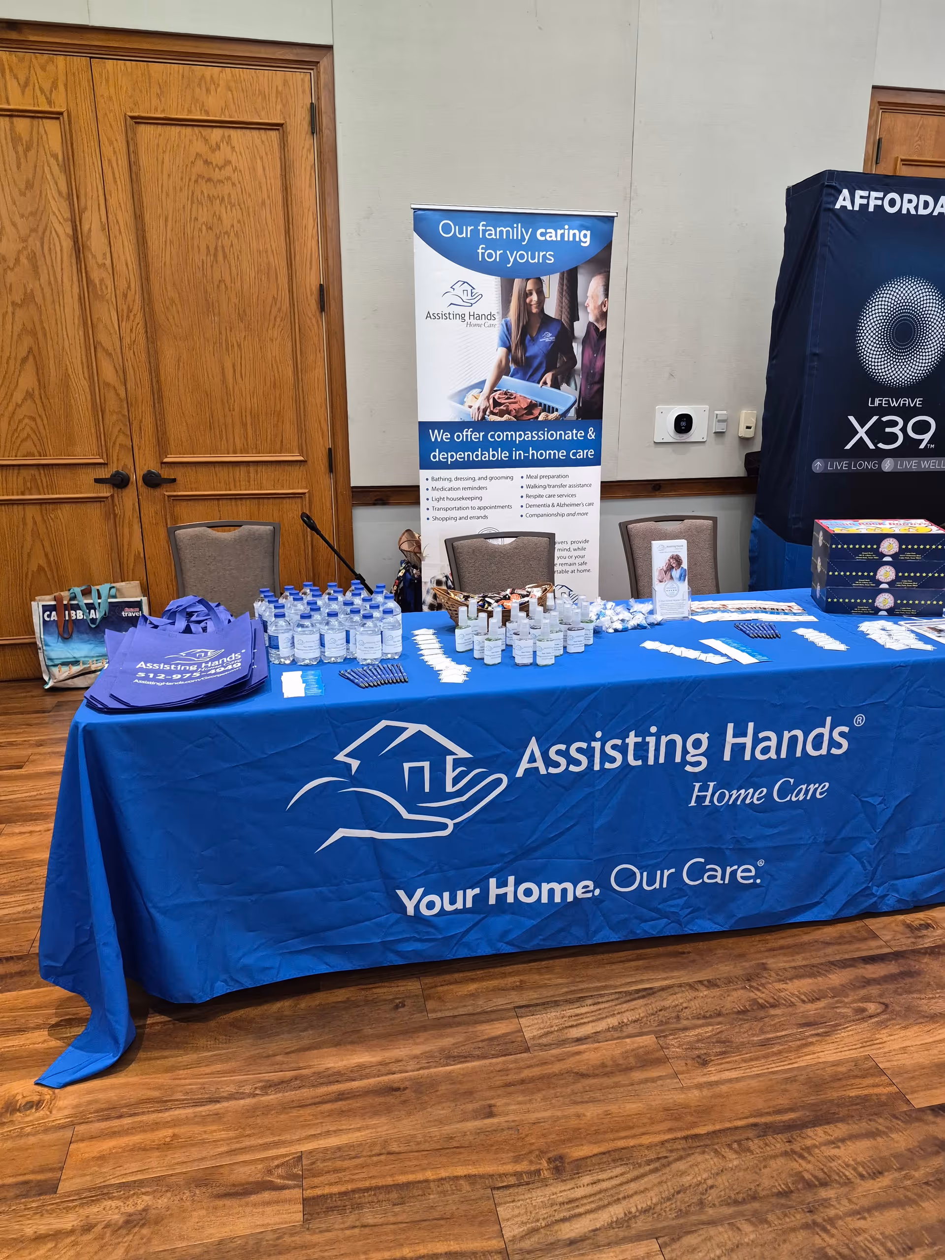 Indoor event booth for Assisting Hands Georgetown with blue table cover.