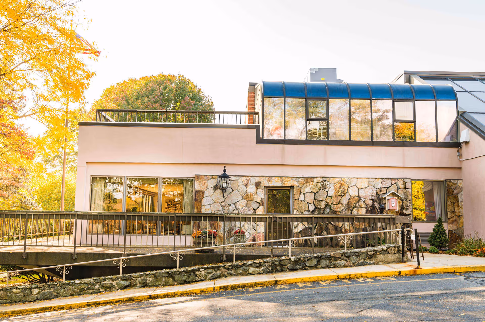 Exterior view of Bear Hill Nursing Center at Wakefield, featuring stone facade and ramp entrance.