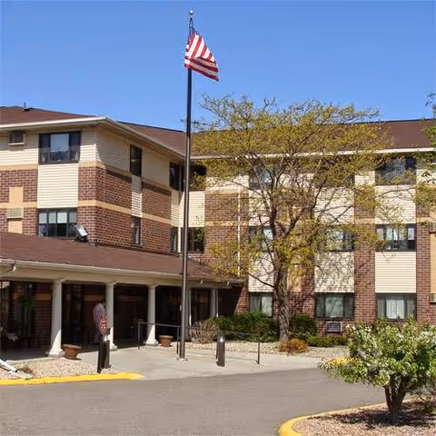 Oak Ridge Manor exterior with flagpole, brick facade, and entrance walkway.