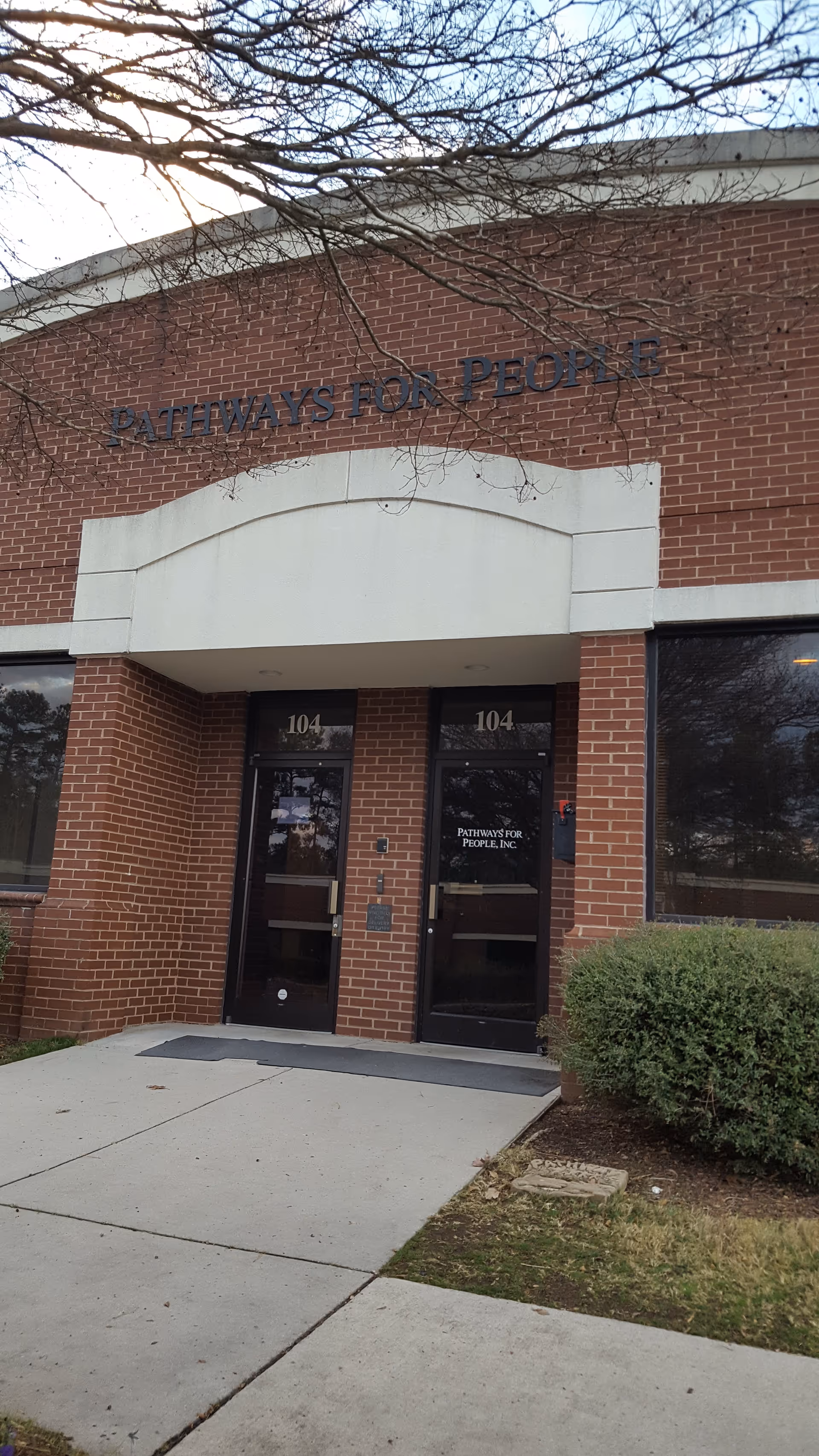 Front entrance of Pathways for People, Inc., brick building with double doors.
