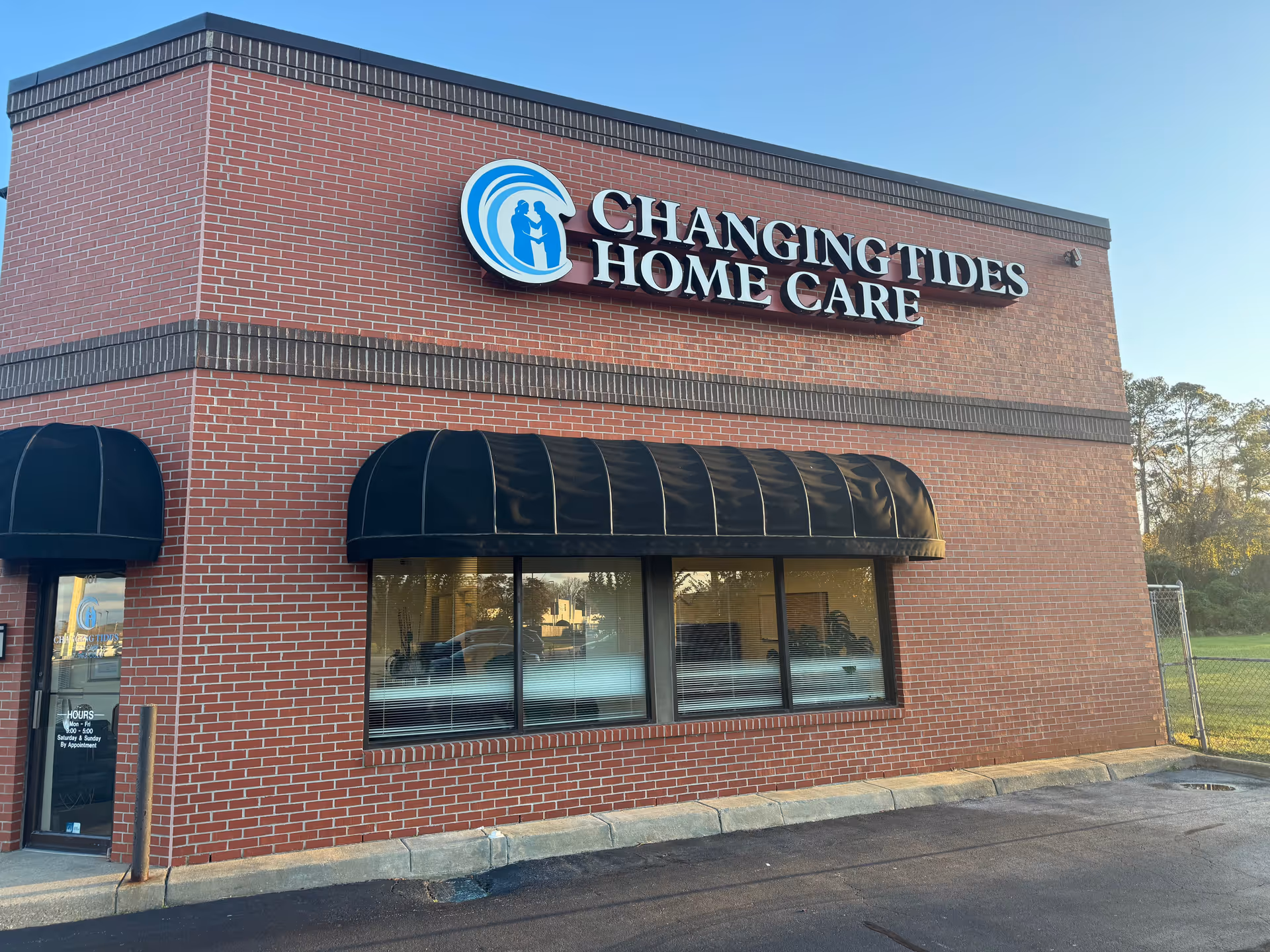 Brick exterior building with Changing Tides Home Care sign and black window awning.