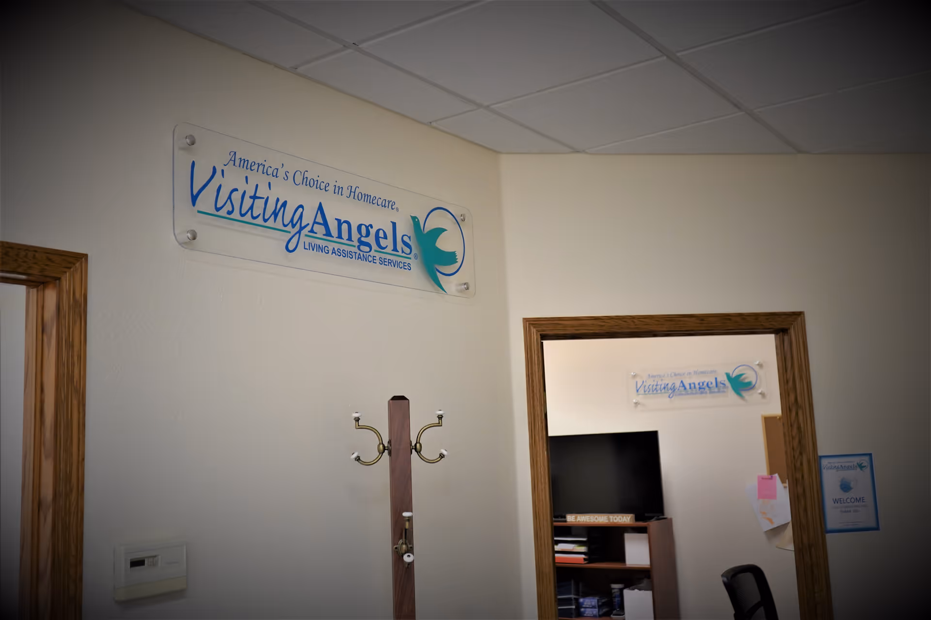 Interior hallway with a Visiting Angels sign on the wall and an adjacent doorway.