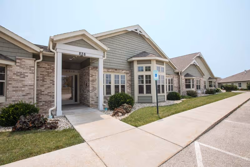 Exterior view of Sunset Ridge Jefferson, a single-story senior living facility with a ramped entrance.