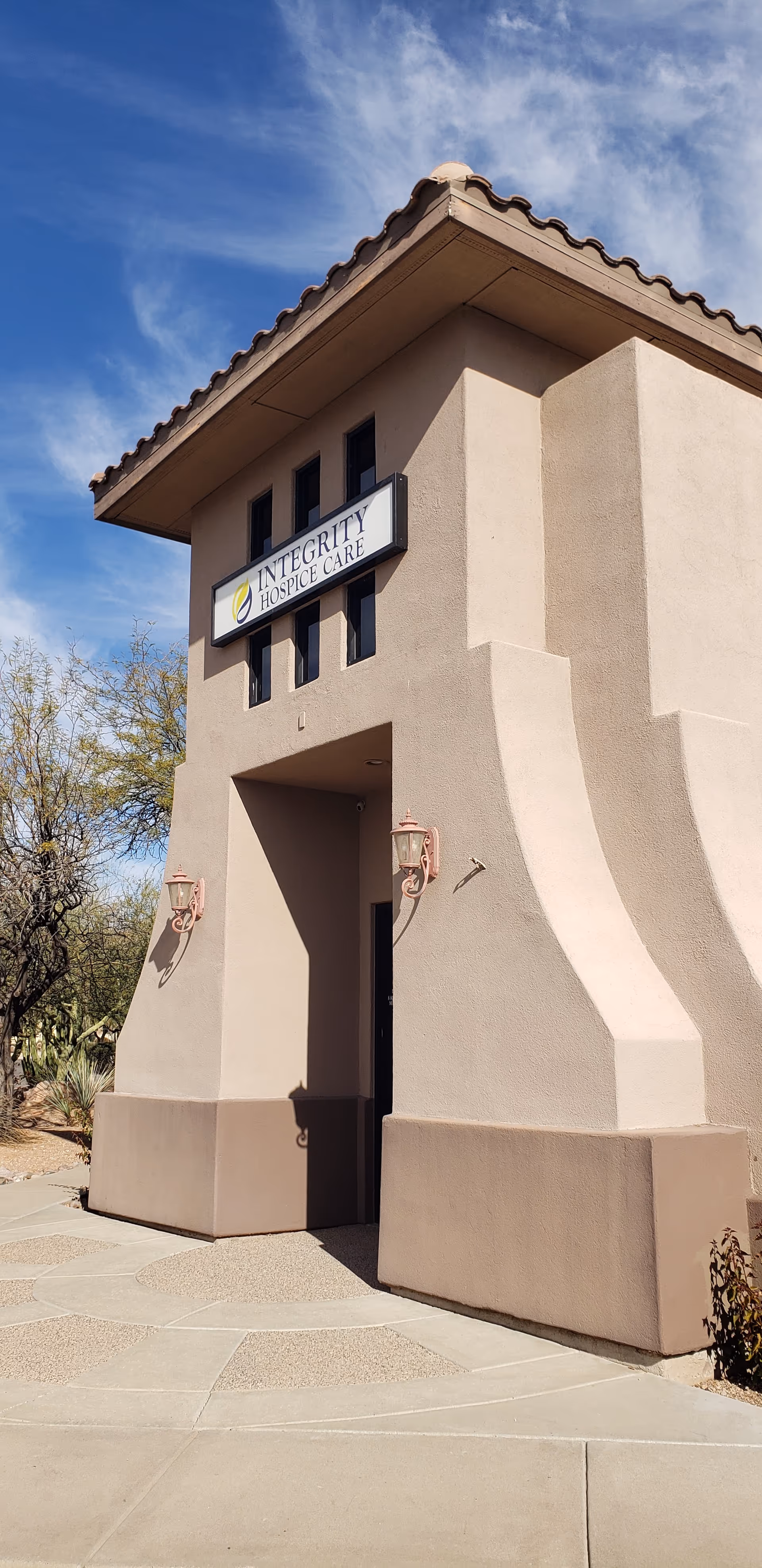 Exterior view of a beige hospice building front with Integrity Hospice Care sign.