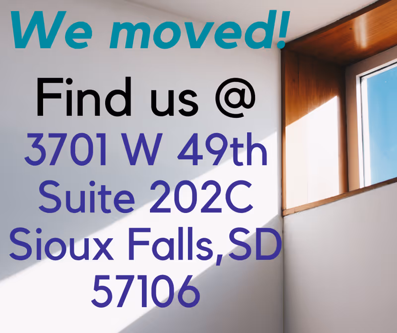 Interior wall displaying large teal 'We moved!' text and address.