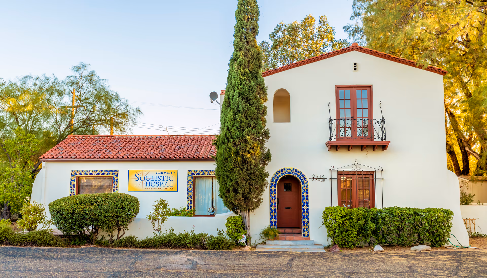 A Spanish-style hospice building with a red-tiled roof and a Soulistic Hospice sign.