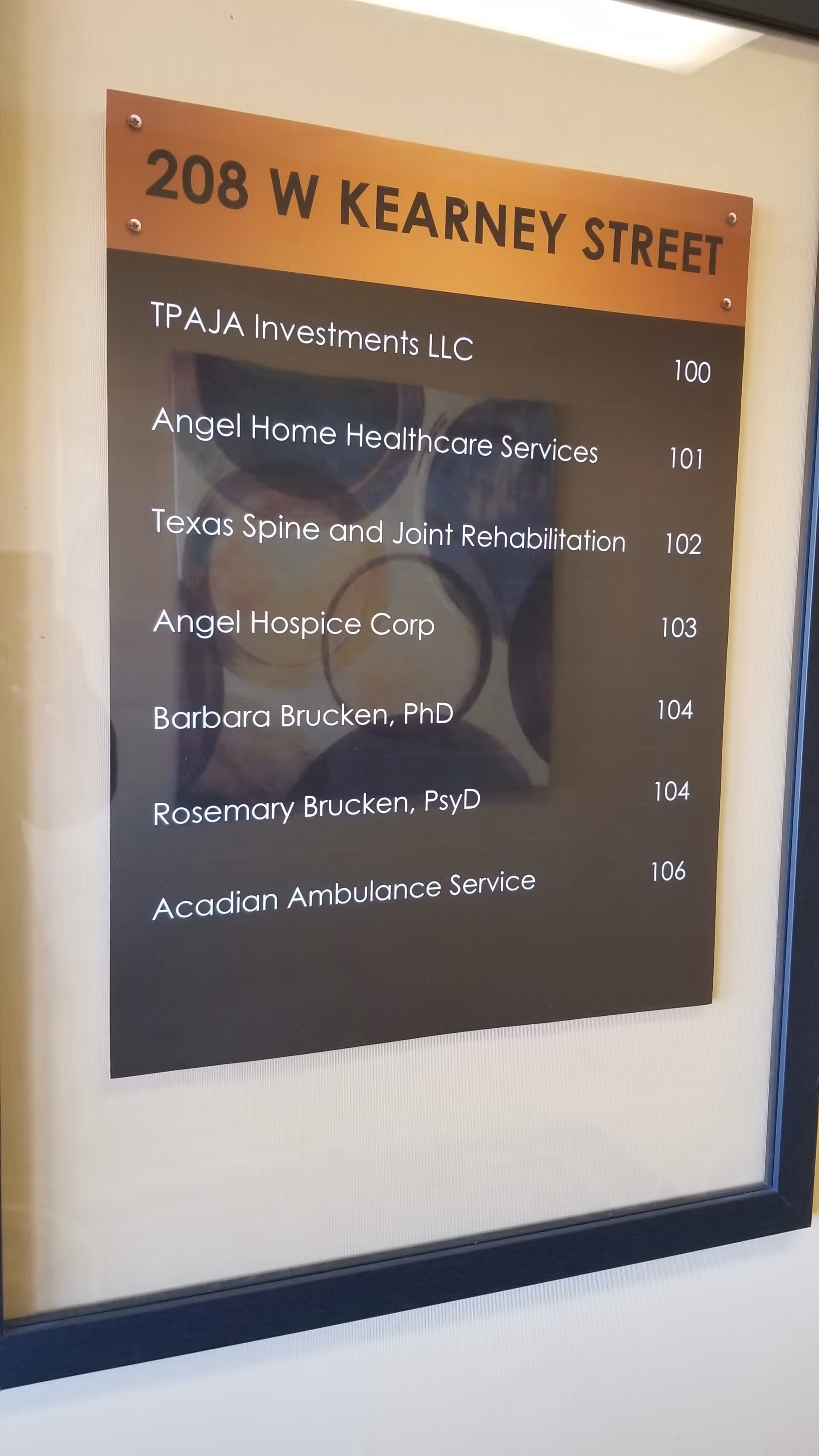 A wall-mounted directory sign listing tenant names and numbers in a hallway.