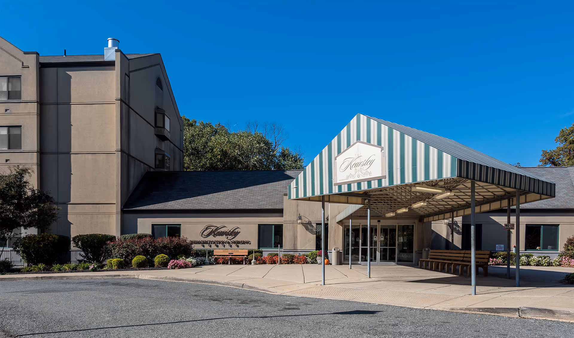 Exterior view of Kearsley Rehabilitation and Nursing Center entrance with striped canopy.