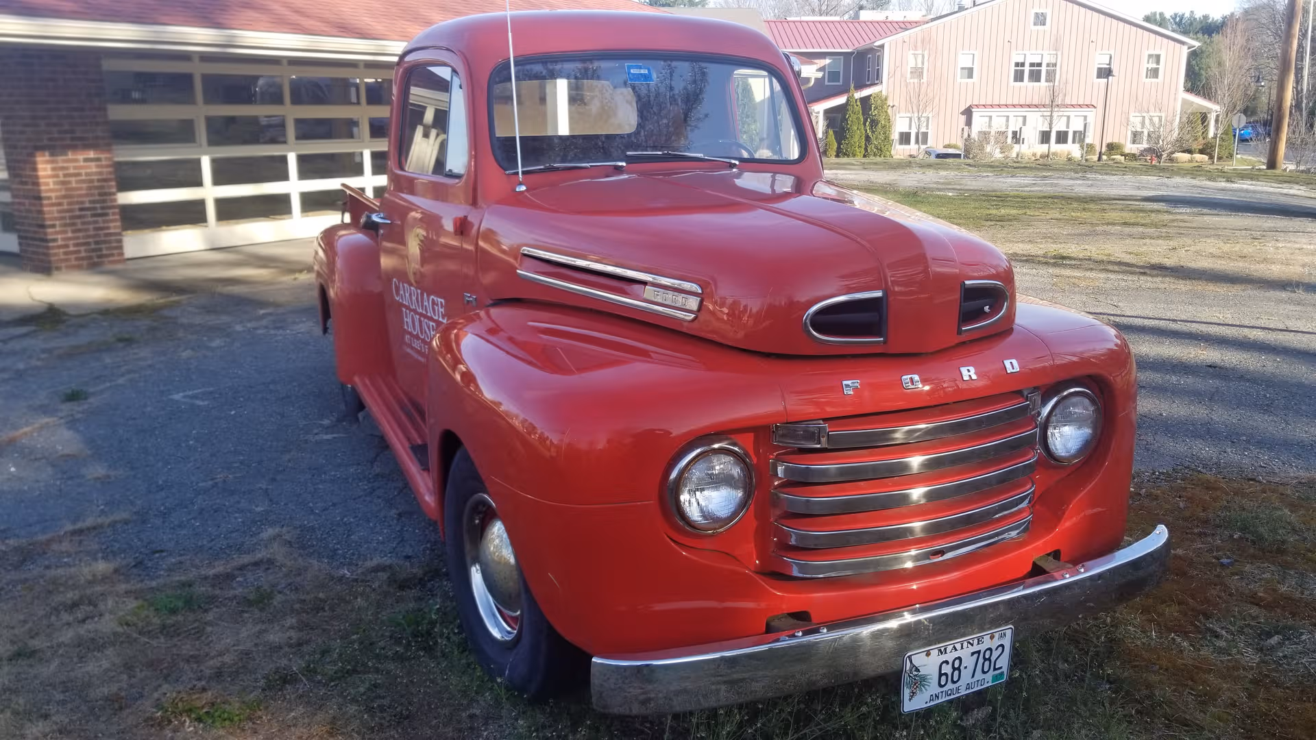 Red vintage Ford truck parked outside Carriage House at Lee's Farm.