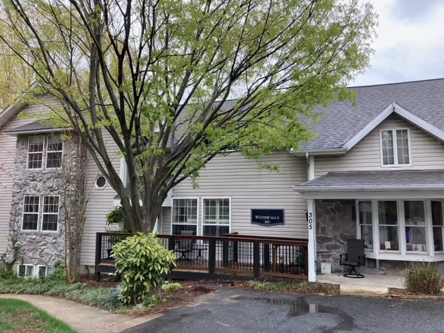 Front exterior of Waterfalls of Catonsville Memory Care, with entrance and trees