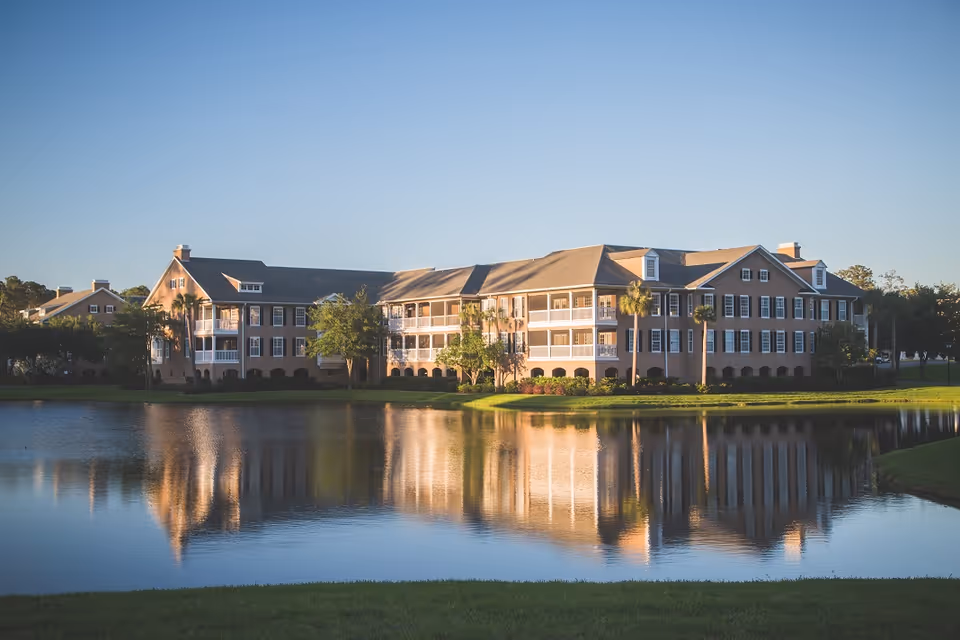 Wide exterior view of Marsh's Edge senior living campus beside a reflective lake.