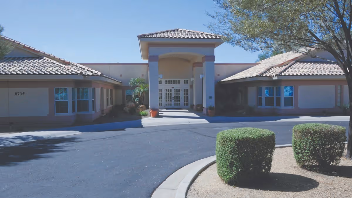 Exterior view of Brookdale North Glendale entrance with driveway and shrubs.