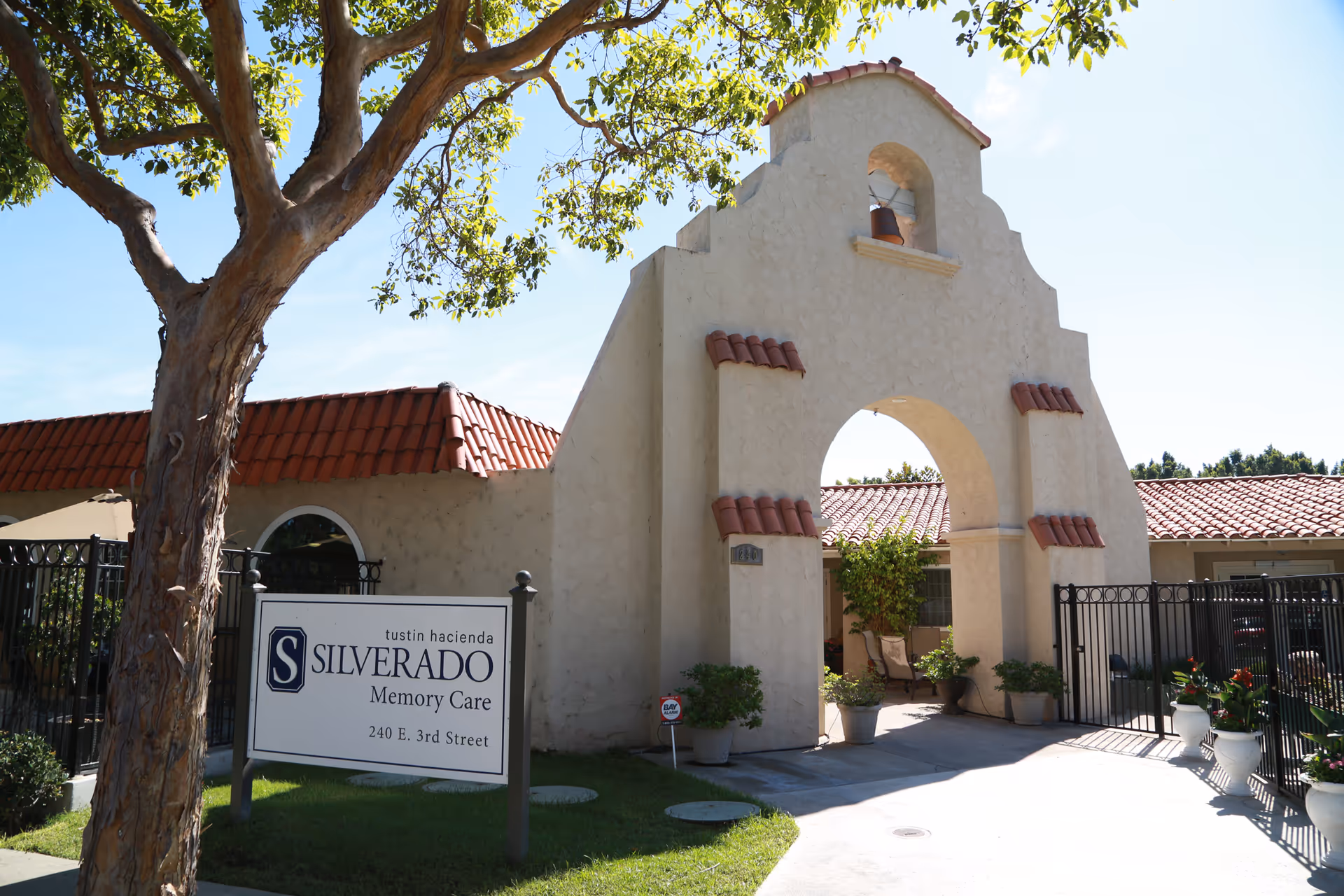 Entrance to Silverado Memory Care building with archway, gate, and sign.
