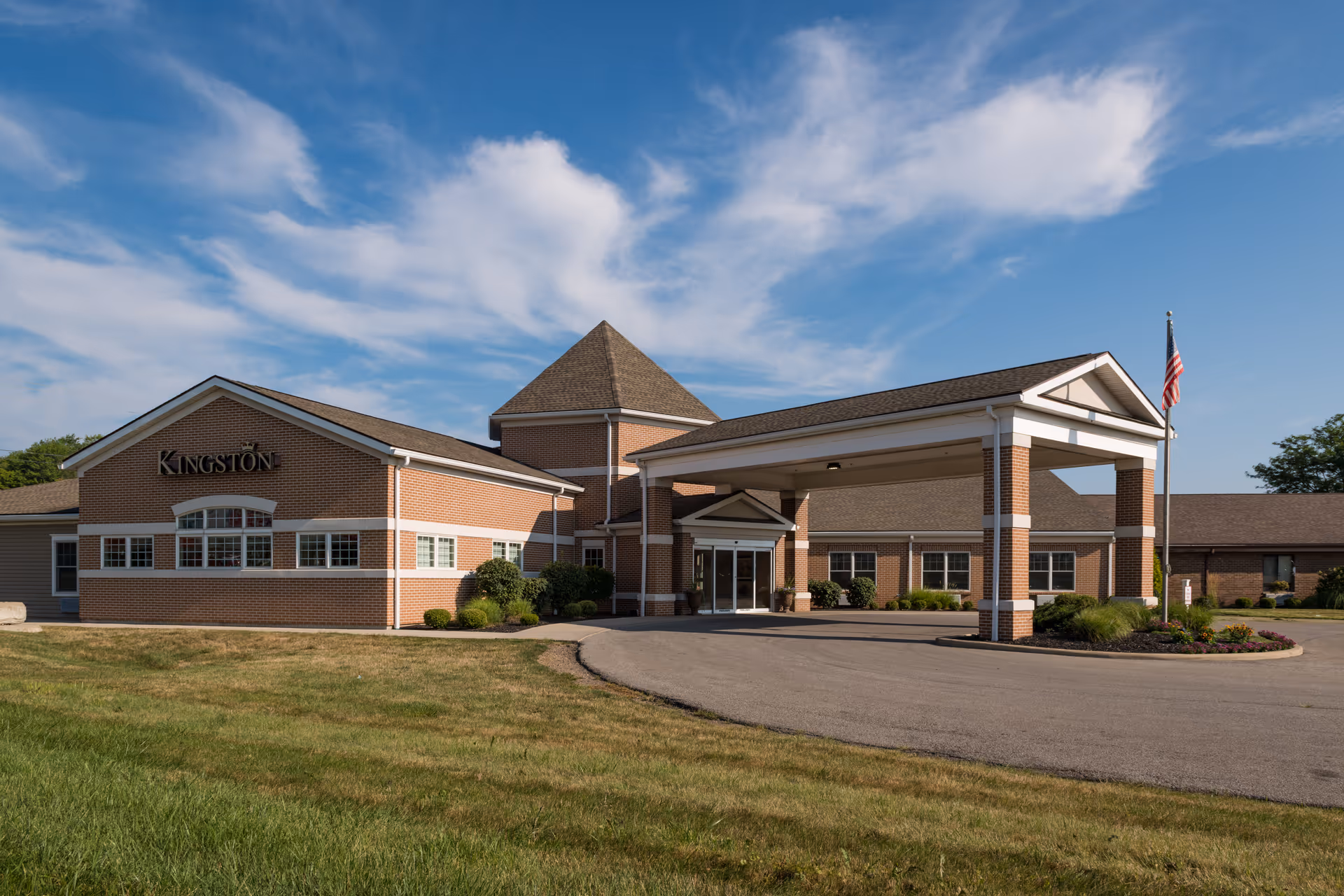 Exterior view of Kingston of Ashland facility with brick facade, entrance canopy, and circular driveway.