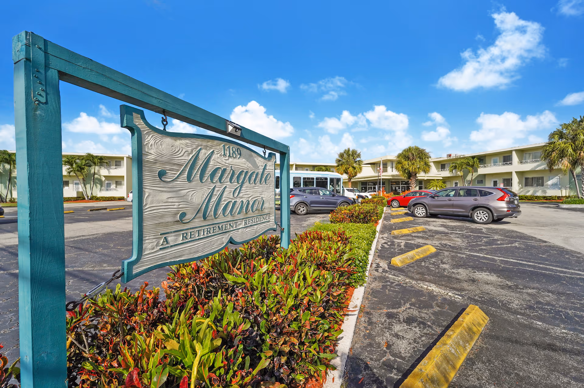 Exterior view of Margate Manor retirement residence with sign and parking.