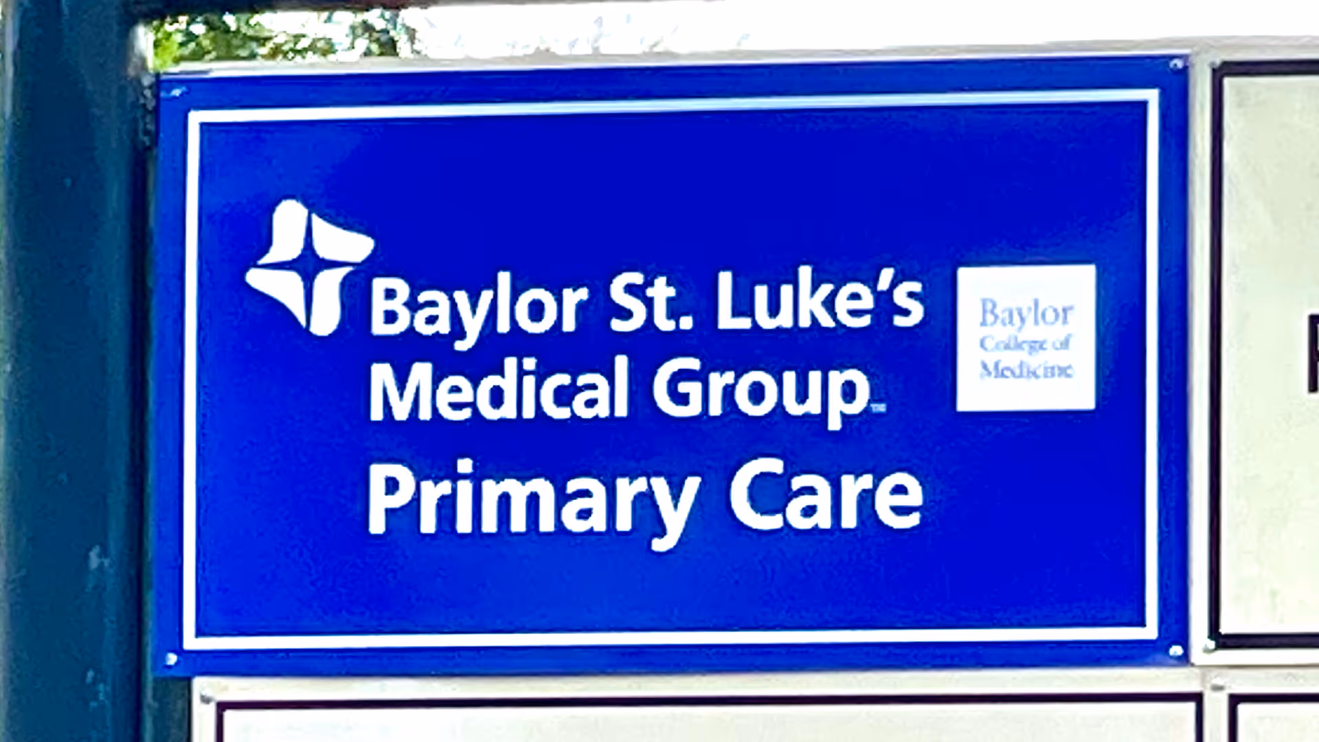 A blue Baylor St. Luke's Medical Group Primary Care sign on a building exterior.