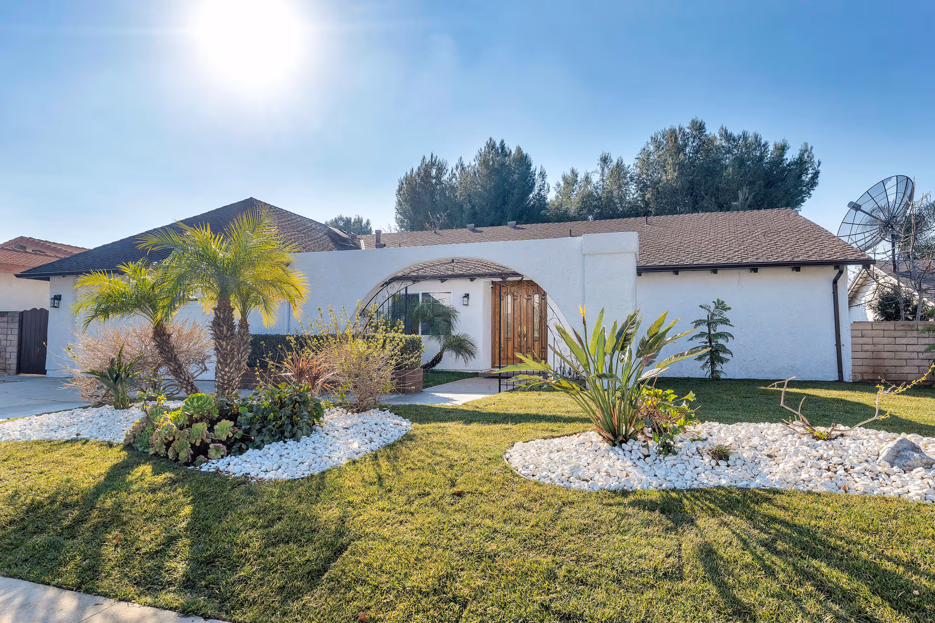 Single-story white facility with a curved entrance and desert-style front yard landscaping.