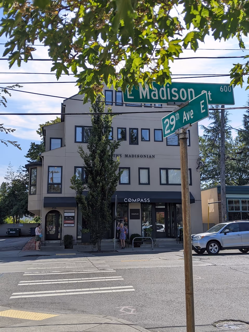 Exterior of a modern building at E Madison St and 29th Ave, with Compass storefront.