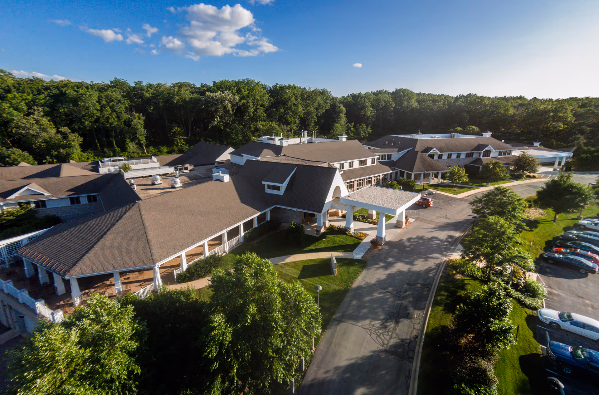 Aerial view of a senior living facility complex with multiple wings and a covered entrance.