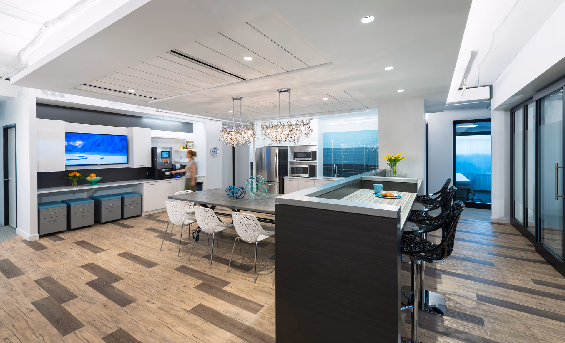 Modern kitchen and lounge area in a senior living facility with an island and seating.