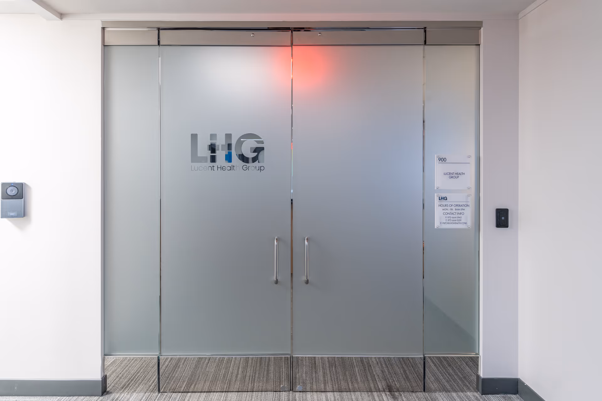 Frosted glass double doors with Lucent Health Group logo in a modern interior hallway.