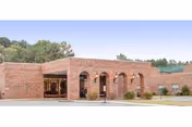 Exterior of Redwood Terrace Assisted Living Community with brick arches and landscaping.