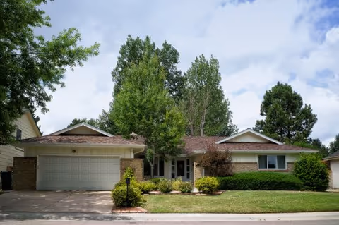 Front view of a single-story building with manicured lawn and trees.