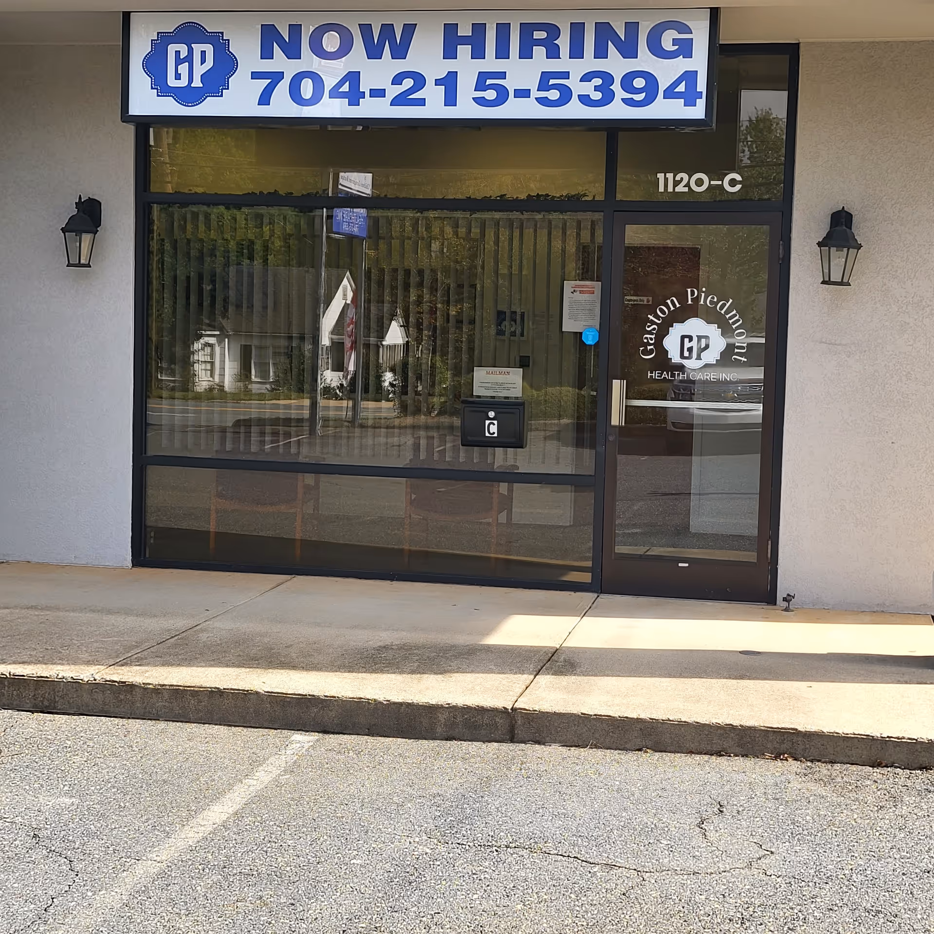 Storefront entrance with a large 'NOW HIRING' banner and Gaston Piedmont Health Care logo.