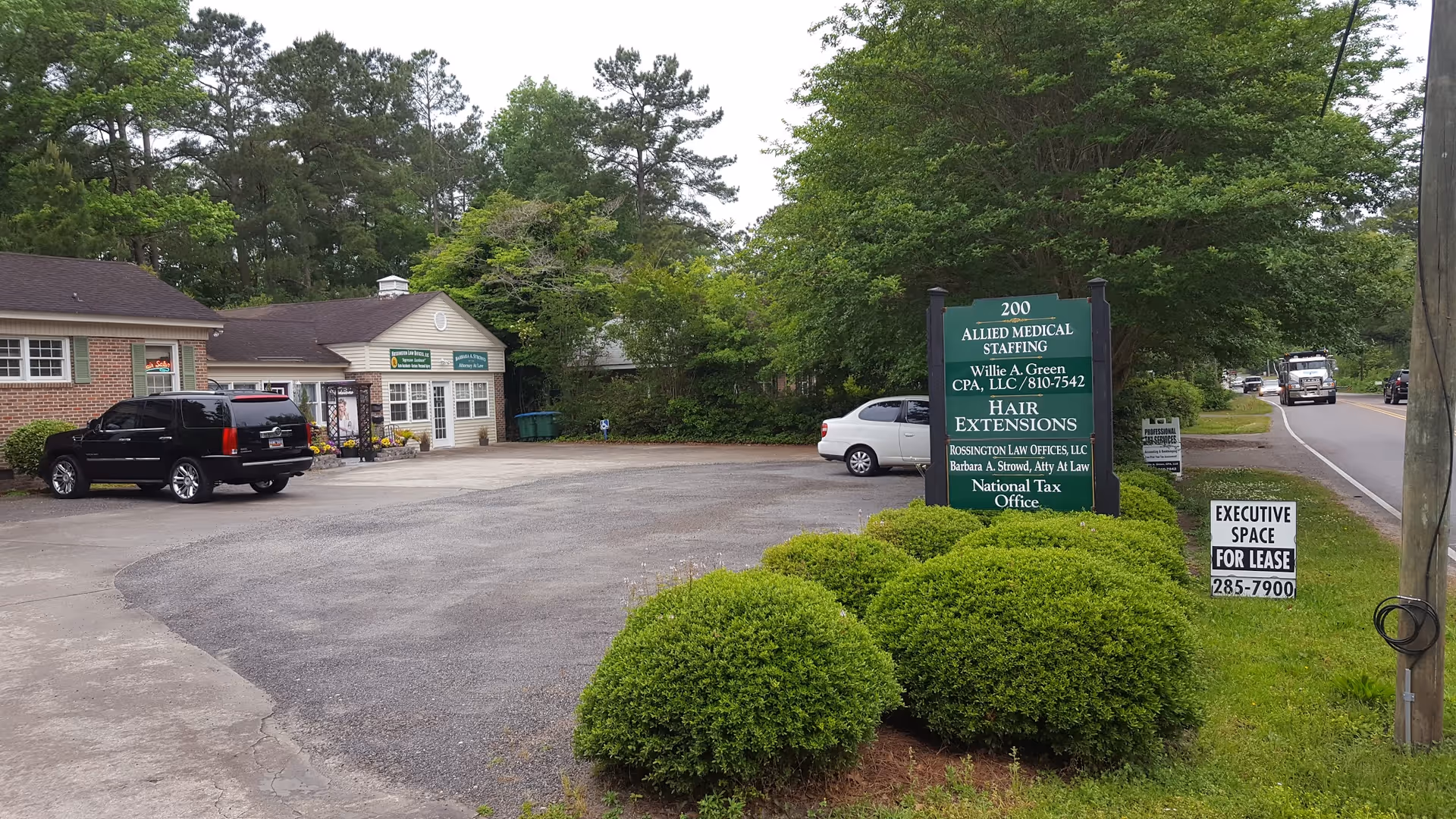 Exterior view of Allied Medical Staffing parking lot with a green sign and office building.