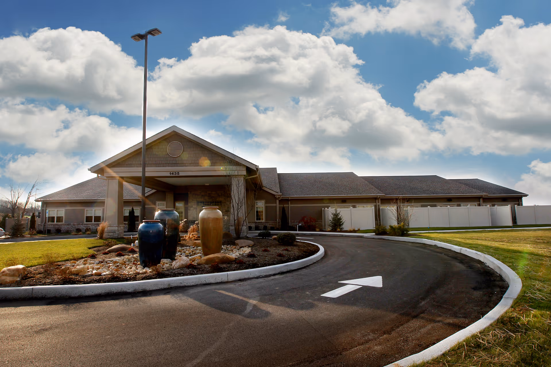Exterior view of Hospice of Hope building with curved driveway and decorative planters.