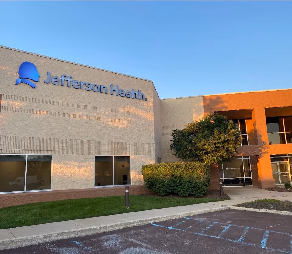 Exterior of Jefferson Health building with blue logo sign and landscaping