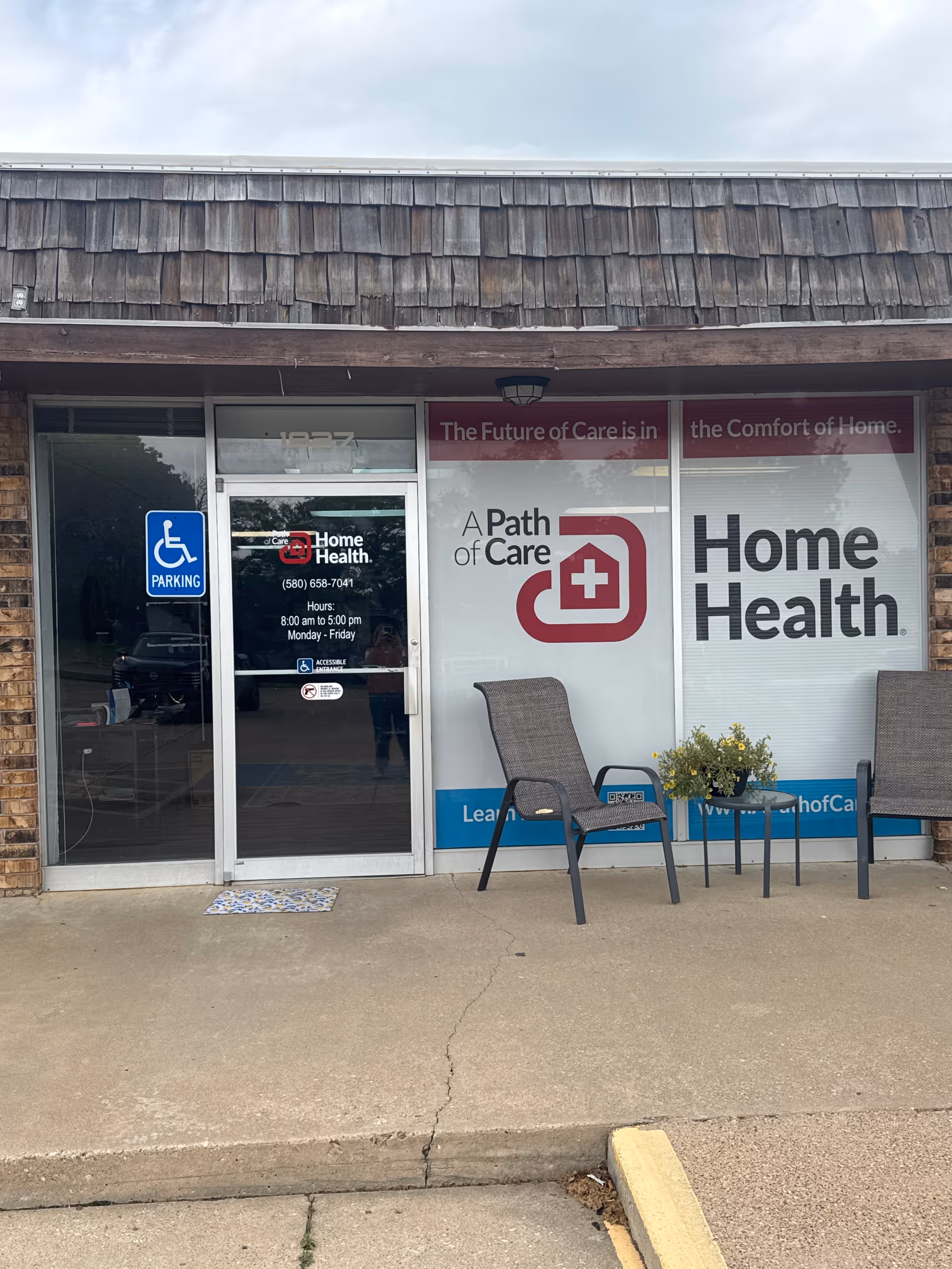 Facade of A Path of Care Home Health storefront with outdoor chairs and handicap sign.