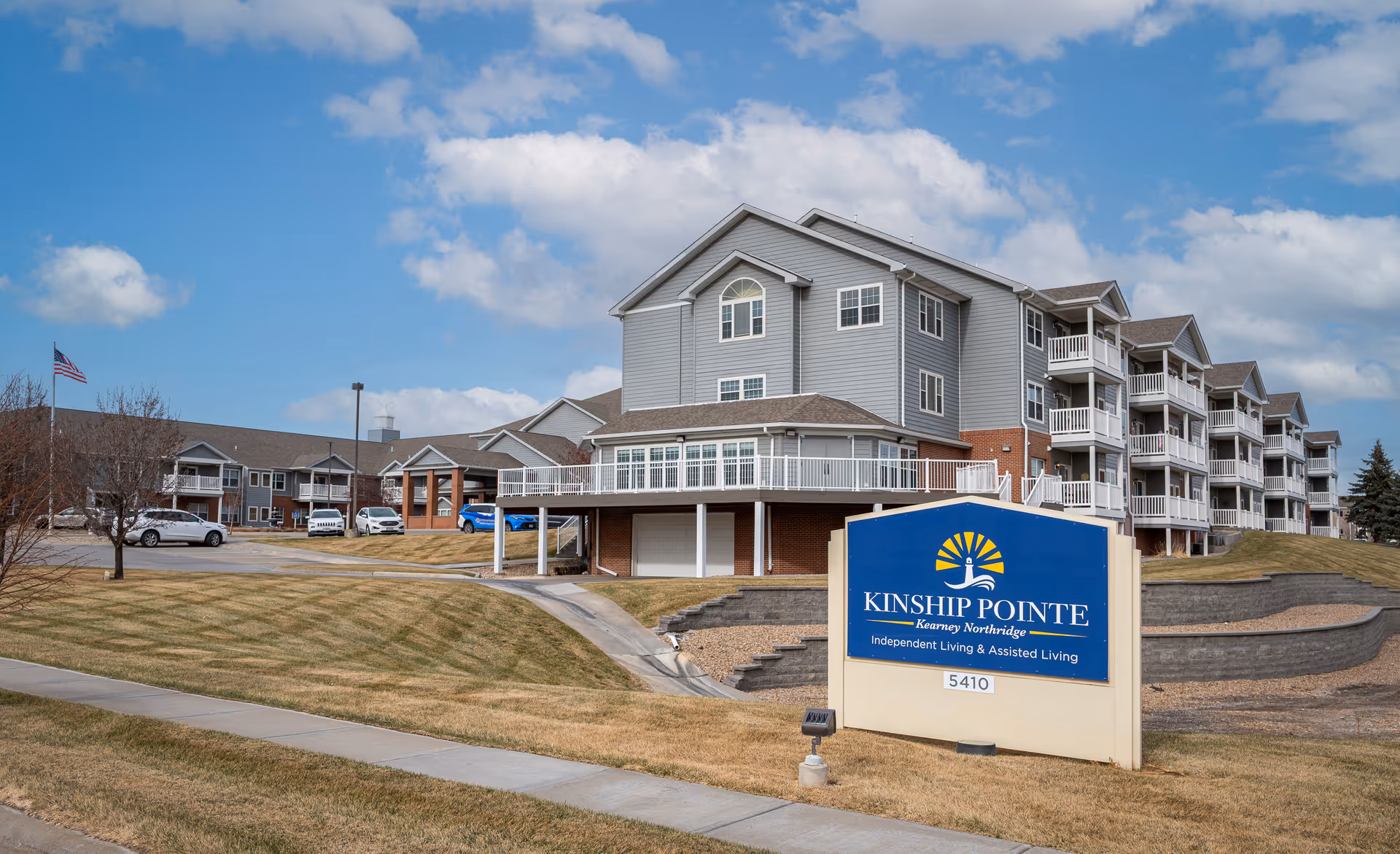 A multi-story Kinship Pointe Northridge exterior with a large blue sign in the foreground.