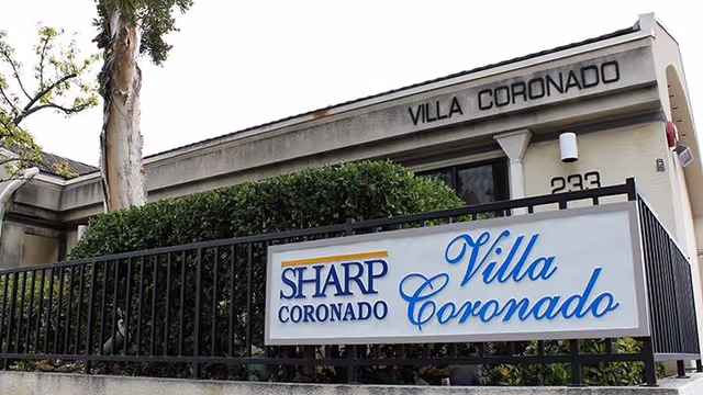 Exterior view of Villa Coronado facility with signage and greenery.